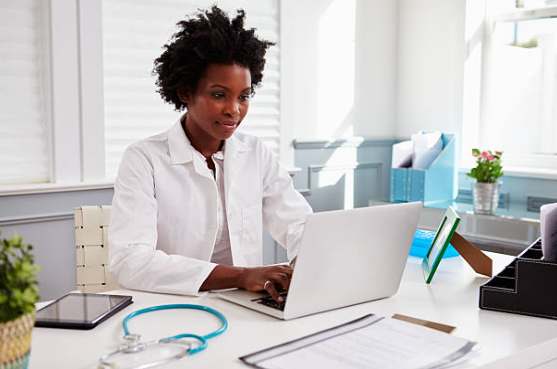 a young doctor sitting at her desk working on the internet