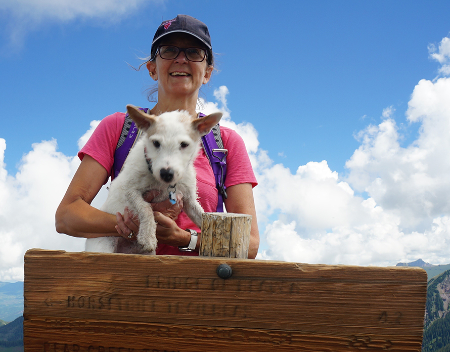 Woman holding dog over sign