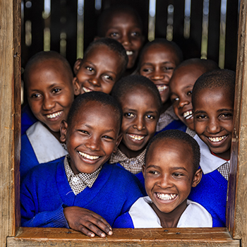 Group of African school children inside classroom, Kenya Violence Against Children and Youth Surveys (VACS) help countries plan for HIV/AIDS epidemic control and support