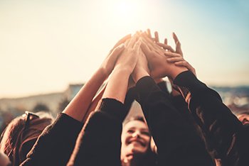 Group of Teenagers Volunteer with Raised Hands to the Sky Striving to reduce youth violence everywhere